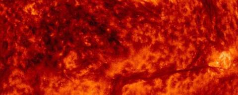Close up of orange and red sun showing coronal mass ejection.