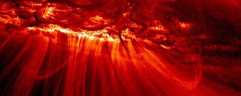 Red close up image of coronal mass ejection on the surface of the sun.