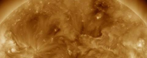 Tan and black image of a fiery corona. 