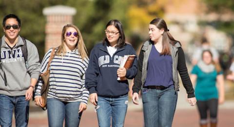 Color photo of students laughing and walking.
