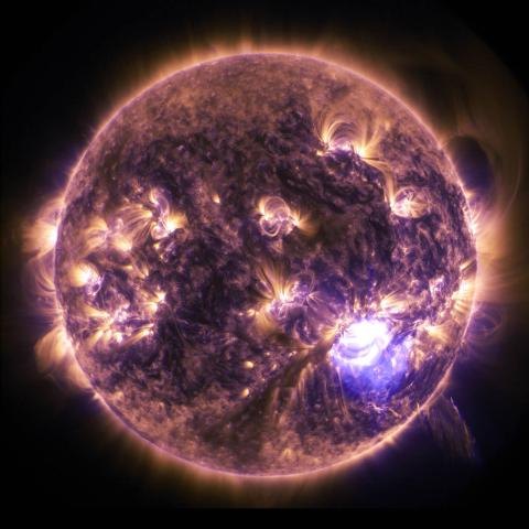 Purple sun in black space with solar flares.