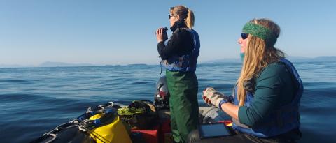 Two women on boat, one with binoculars.