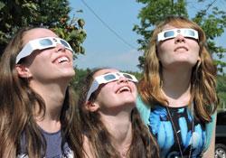 three girls viewing an eclipse