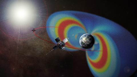 Two spacecraft near the colorful radiation belts that surround Earth.