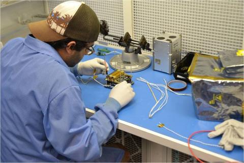 Student working on electronic component of FIREBIRD CubeSat.