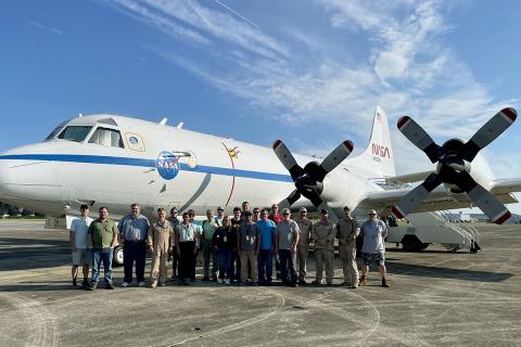 Group photo of people in front of plane for MAGEQ.