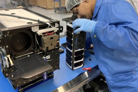 Photo of student working on cubesat.