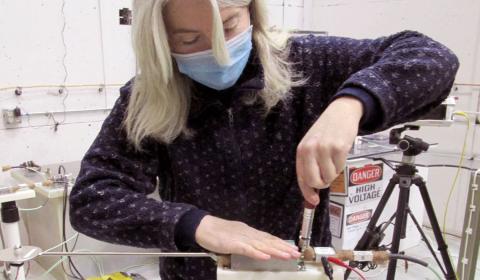 Julia Tilles setting up a Ddot (electric field probe) for electrical breakdown experiments. Julia Tilles holding probe.